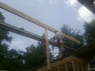 Carpenter setting a ridge beam over a new addition frame — Ice Dam Removal by Roofing Brothers in Burlingame